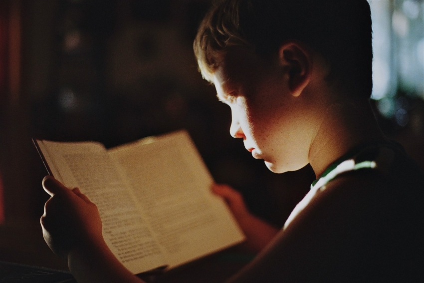 Kind liest in einem Buch